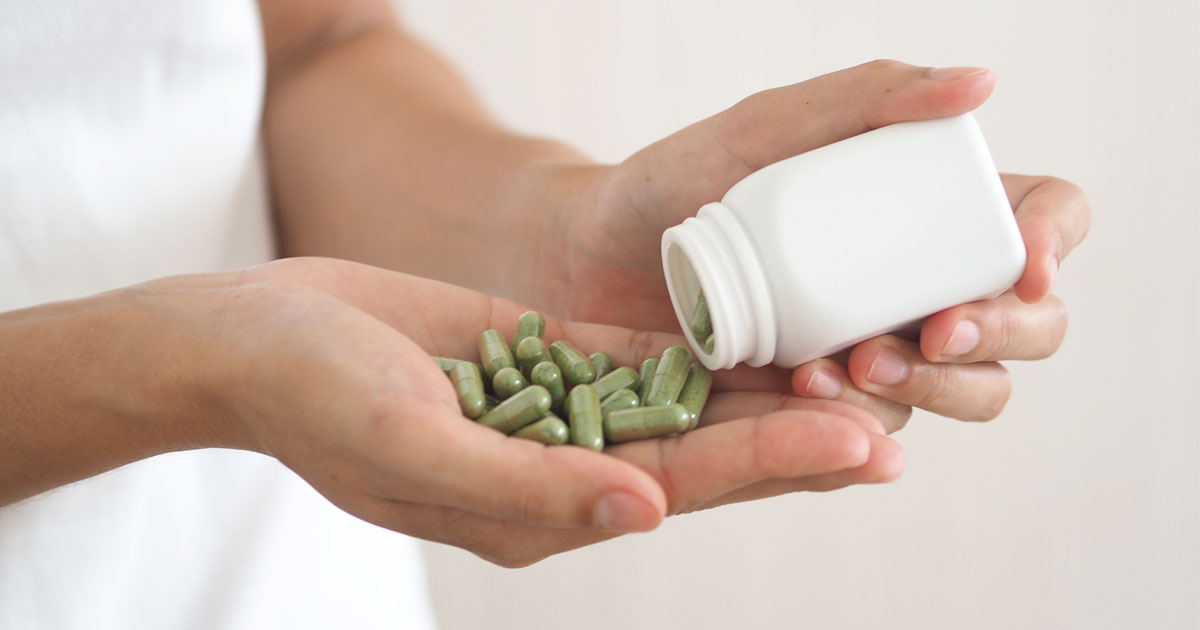 Close-up of a woman taking herbal supplements.