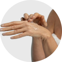 A mature woman applying gel to her upper arm.