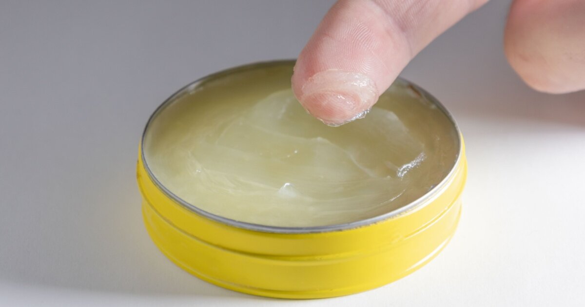 Close-up of a finger covered in petroleum jelly.