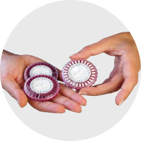 A close-up of a woman holding several pill packs