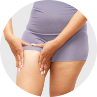 Close up of a woman in gym clothes squeezing her upper thigh