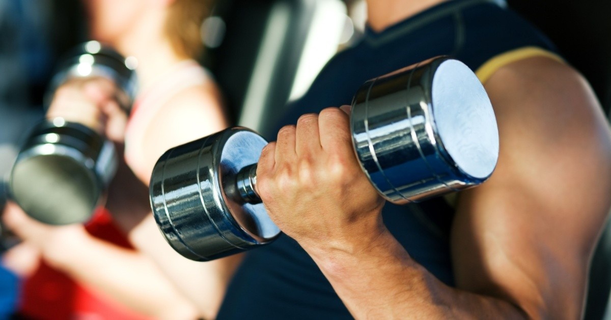 Close-up of a man lifting dumbbells. 