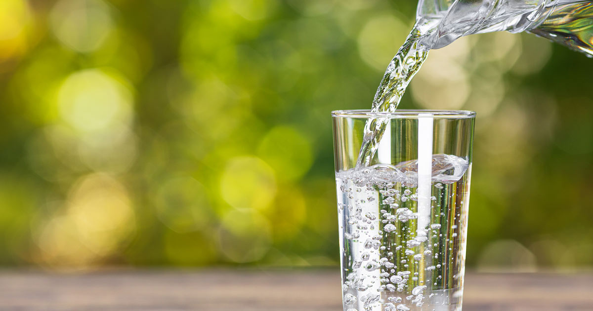 Jug pouring water into glass.