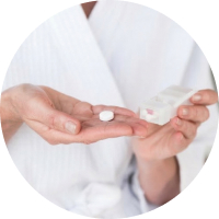 A close-up of a woman in a white gown putting a tablet into her hand.